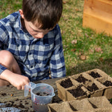 Child planting seeds in a CowPots® #3 6-cell