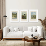 Living room with a white sofa, wooden coffee table, and three framed Monet Set of 3 Printable Exhibition Posters on the wall.