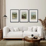Living room with a white sofa, wooden coffee table, and framed Monet Set of 3 Printable Exhibition Posters on the wall.
