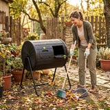 Woman using a compost bin in her garden with tools nearby.