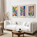 Modern living room with a white sofa, wooden coffee table, and Modern Colorful Floral Matisse Wall Art Set on the wall.