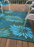 Green and blue floral patterned Daisy Aqua & Green rug on a wooden deck