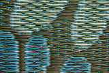 Close-up of a textured fabric with wavy pattern in green and blue tones.