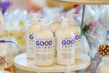 Bottles of 'A Bottle of Good Things' on a shelf with decorative items in the background