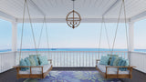 Two wooden swing chairs with blue cushions and Daisy Blue rug on a covered porch with ocean view.