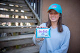 Person holding a bar of soap labeled 'Sea Salt' on a wooden deck.