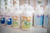 Row of hand soap bottles with various designs and text on a countertop.