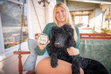 Woman holding a black dog and ALMOND ARNICA SALVE 8 oz. ~ ALMOND MILK