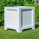 White outdoor Eastover planter box on grass with greenery in the background