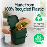 Green compost bin with food waste, person holding a cutting board, and recycling symbols on a light background.