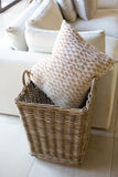 Wicker basket with patterned pillow on a light-colored sofa
