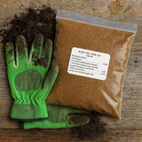 Green gardening gloves and a bag of Boer Fish Meal 60 on a wooden surface