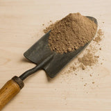 Trowel with Archipelago Bat Guano 0-7-0 (5 lb bag)on a wooden surface