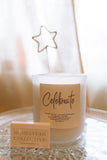 Candle with 'Celebrate' label and soap bar from Homestead Collective on a white surface.
