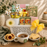 Tea gift set with tea bags, cookies, and a cup of tea on a wooden table. Planted With Love Cookies & Tea Gift Basket