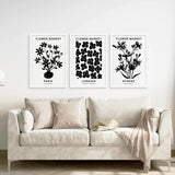 Flower Market Black and White Art Set Decor above a beige sofa.