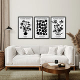 Living room with a white sofa, wooden coffee table, and Flower Market Black and White Art Set Decor on the wall.