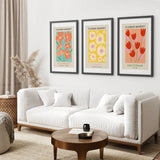 Living room with a white sofa, wooden coffee table, and 3 Piece Botanical Boho Art Set. Flower Market Theme
