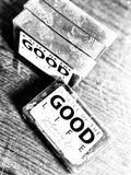 Two 'Good Life' soap bars on a wooden surface