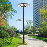 4500W Solar Outdoor Light Round 360° Wide Angle UFO Garden Pole And Wall Street Lights with Remote in a park with buildings and greenery in the background