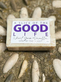 Bar of soap with 'A Slice of the Good Life' label on a natural stone background