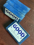 Two blue containers labeled 'A Slice of the Good' on a wooden surface.