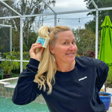 Woman applyingcSHAMPOO BAR 5 oz. ~ VANILLA COCONUT MILK to her hair outdoors near a pool