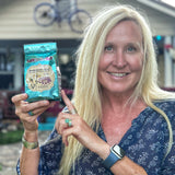 Woman holding a ROSEMARY MINT & ARNICA BATH SALTS 16 oz. OR 32 oz.