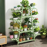 Indoor Outdoor 12-Shelf Green Wood Triangular Flower Pot Plant Stand with various potted plants against a white wall.
