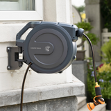 Retractable hose reel mounted on a wall with a garden hose attached, featuring Giraffe Tools branding.