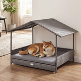Dog lying on a gray pet bed with a canopy in a home setting