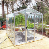 Janco Glass greenhouse with plants inside, surrounded by trees and garden area.
