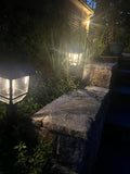 Outdoor garden scene with stone steps and illuminated lanterns at night.