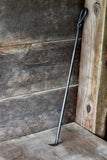 Wood Stove Fire Poker leaning against a wooden wall