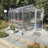 Janco Palmetto Greenhouse greenhouse in a garden with flowers and plants around