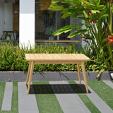 Wooden table on a patio with greenery in the background Eve FSC Teak Outdoor Conversation Set with Cushions