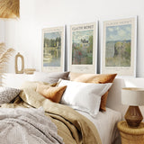 Bedroom with a bed featuring pillows and blankets, Monet Set of 3 Printable Exhibition Posters of Claude Monet's paintings, and a lamp.