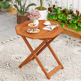 Wooden folding table with tea set and newspaper on a patio