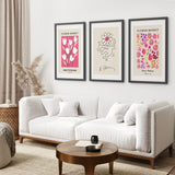 Modern living room with a white sofa, wooden coffee table, and framed Keith Haring & Matisse Pink Set of 3 Prints on the wall.