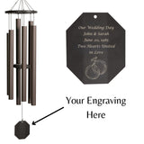 Decorative wind chime with engraved text on a white background