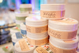 Jars of 'The Lily Garden' body cream on a blurred background