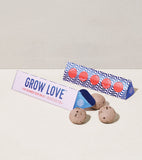 Grow Love product packaging with two balls on a light background