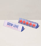 Two packaging boxes for 'Grow Love' product on a light gray background Bright Side Seed Balls