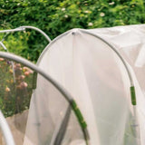 Close-up of a DIY Portable Low Tunnel Kit with green plants inside, set against a blurred garden background.