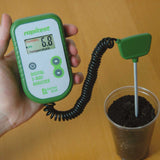 Rapitest digital 3-way analyzer measuring soil parameters on a wooden surface