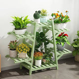 Indoor Outdoor Bamboo Wood 6-Shelf Flower Pot Plant Stand in Green Finish with various potted plants against a white wall.