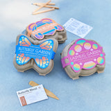 Two egg carton halves labeled 'Butterfly Garden' and 'Ladybug Garden' on a blue surface.