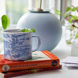 Blue marbled mug on a stack of books with a blurred background Altered Herb Mug Grow Kits