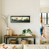 Modern living room with a wall-mounted plant display and a person in the background. Smart Landscape Growframe