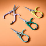Four pairs of colorful scissors on an orange background